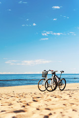 Fototapeta premium Pair of bikes left at the seaside on blue cloudy sky background.