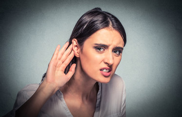 nosy woman hand to ear carefully listens in on gossip conversation. Hard to hear.