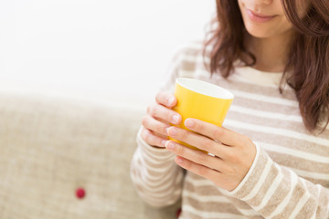 部屋でお茶を飲む女性　手元