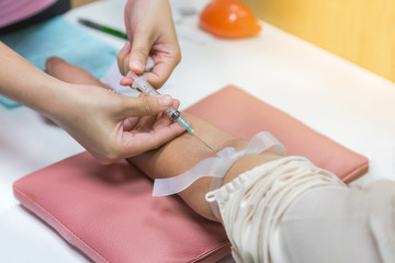 nurse inject needle syringe in the arm patient drawing blood sample for blood test in laboratory