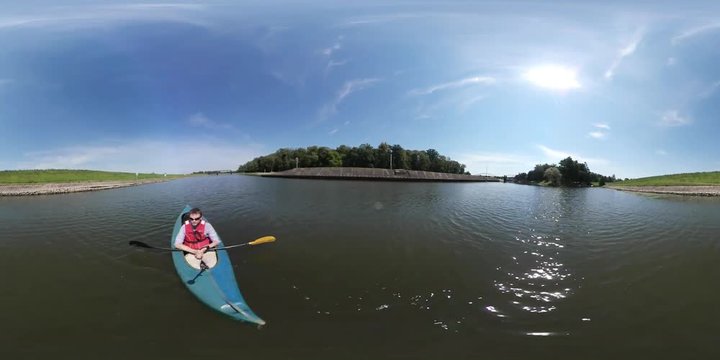 360Vr Video Man is Kayaking by River Looks Around Sunny Summer Day Man Has Sports at the Nature Green Trees Grass Island in a Middle of a Pond Blue Sky