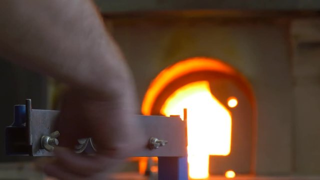 the Man Imparts Round Form to a Glass Preform With Help of a Small Metal Tweezer
