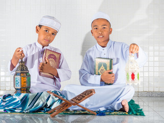 asian muslim children holding holy Quran