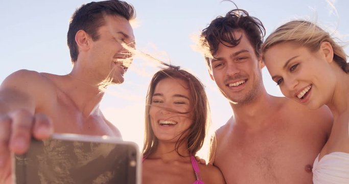 Friends taking a selfie together on a beach 