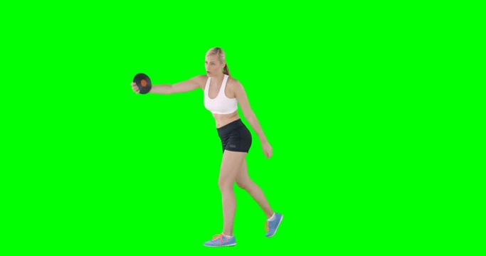 Woman launching a discus front of a green screen