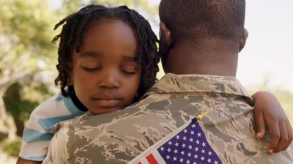 American soldier is hugging his son  - Powered by Adobe