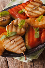 Healthy fruits grilled with mint close up on the table. vertical
