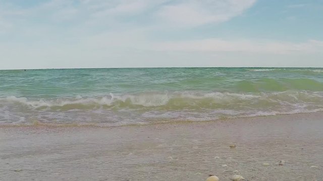 Static scene. Blue sky and sand. Sea water, waves