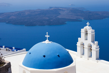 The Three bells of Fira and blue dome, Santorini, Greece with Santorini's volcano in the background - obrazy, fototapety, plakaty