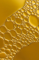 gold drops of oil and air bubbles on the water