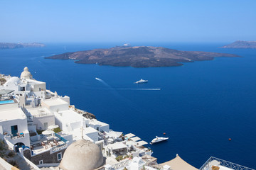 Fototapeta premium White houses of Fira, Santorini with Santorini's famous volcano in the background