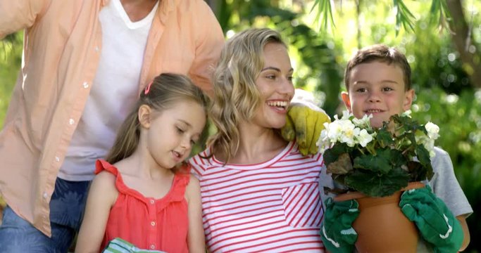 Portrait of cute family are posing during the gardening on a sunny day