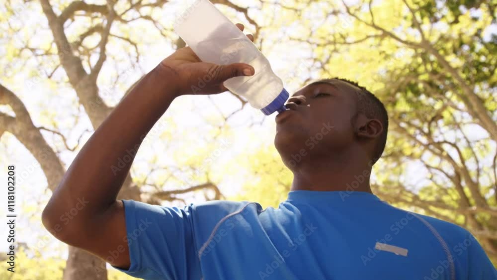 Poster Low angle view of sportsman is drinking to a flask 