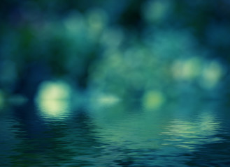 Abstract circular bokeh reflected in water.