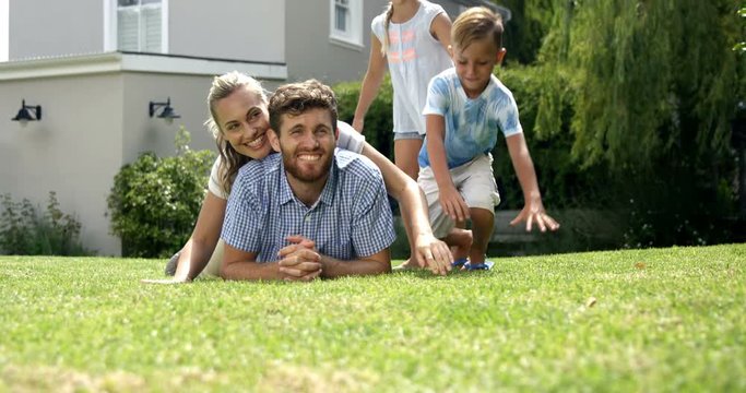 Portrait of happy family lying on the floor in the garden