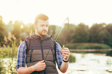 Fisherman with a spinning rod and bait (lure, wobbler)  catching