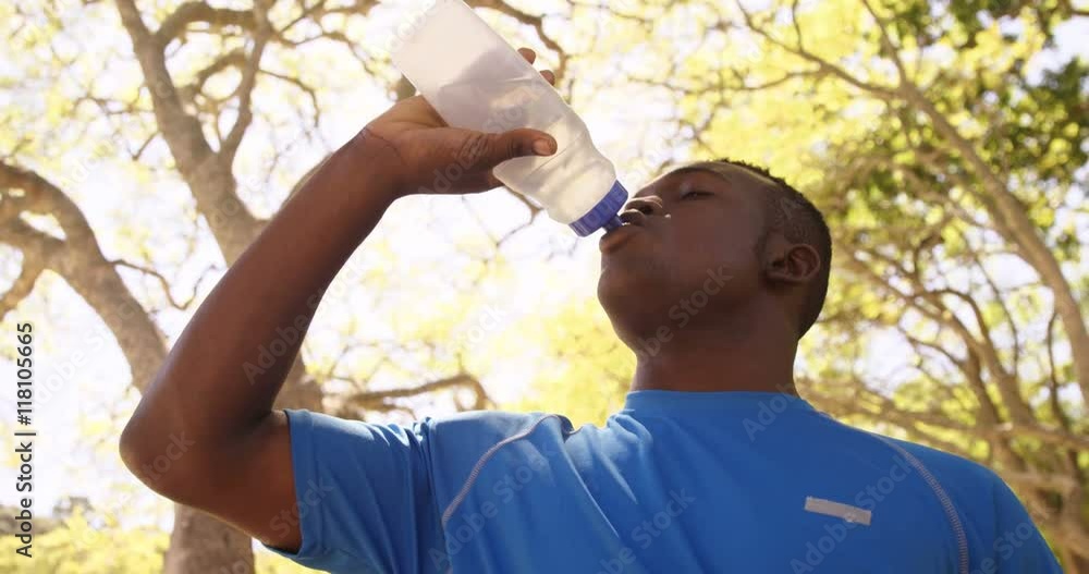 Poster low angle view of sportsman is drinking to a flask