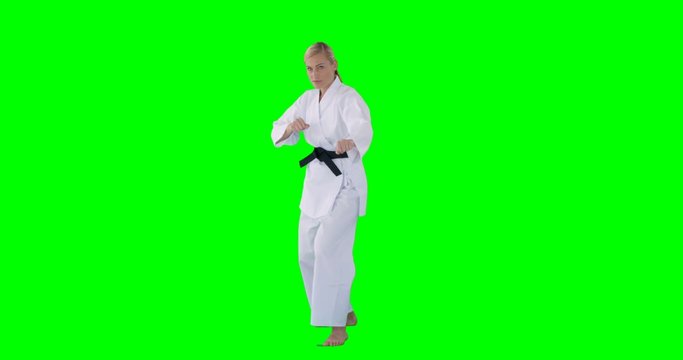 Woman doing judo on a green background