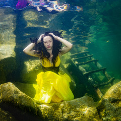 The girl in a dress under water