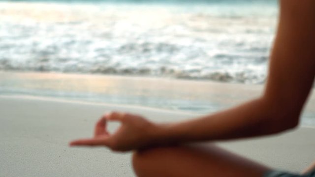 Woman performing yoga on beach 
