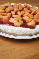 cheesecake al melone e gelatina di fragole su piatto su tavolo di legno