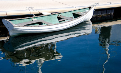 Fototapeta na wymiar White rowboat parked in Victoria Bay, British Columbia