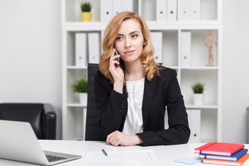Business lady talking on her phone and looking serious