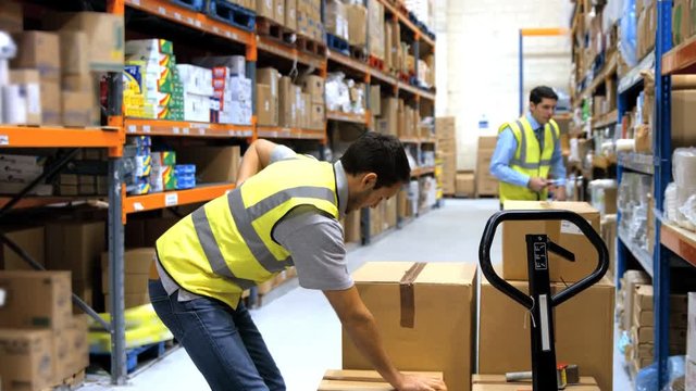 Worker with backache while lifting box