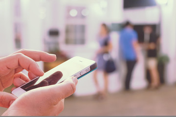Girl use mobile phone, blur image of reception in hotel as backg