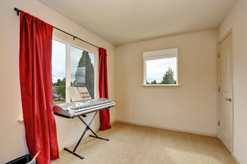 Beige room interior with synthesizer and red curtains