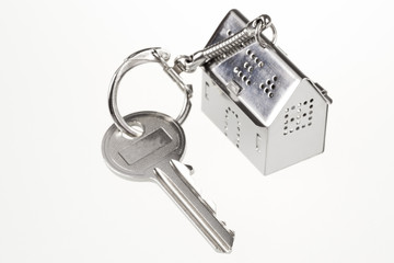 key with keychain in the form of a silver-colored house on a white background