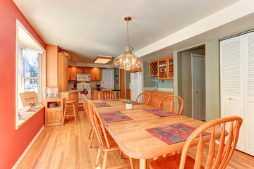 Red dining room interior with large wooden table and chairs
