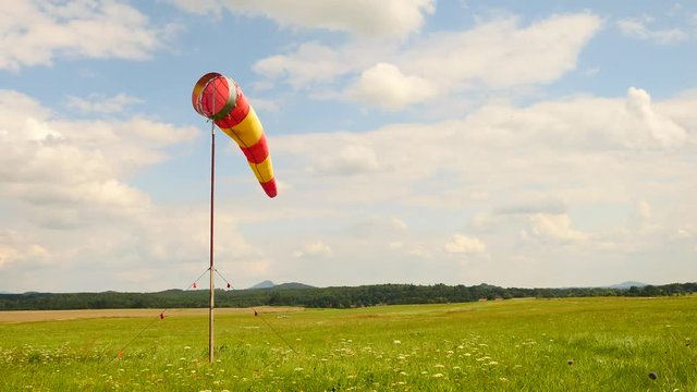Summer hot day on sport airport with abandoned windsock, wind is blowing and windsock is moving