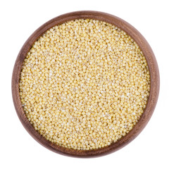 Yellow millet in a wooden bowl on white background. The small seeds are grown as cereal crops or grains for fodder and human food. Edible, raw and organic food. Isolated close up macro photo.