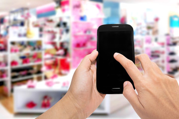 Woman uses a smartphone on shopping in the department store.