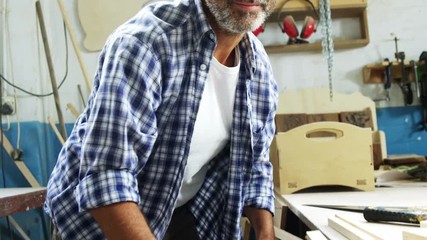 Portrait of smiling carpenter measuring 