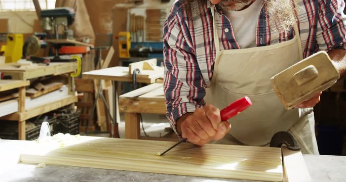 Carpenter using hammer and chisel 