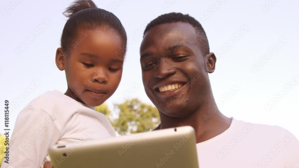 Poster man looking a tablet computer with his daughter