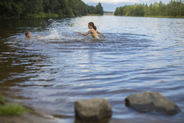 Two naughty girls bathe in the lake.