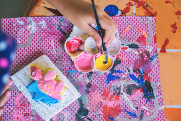 kid painting on the plaster statue.