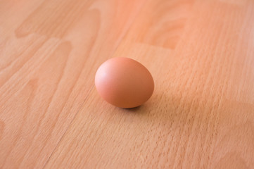 Hen egg on wooden table/ floor background