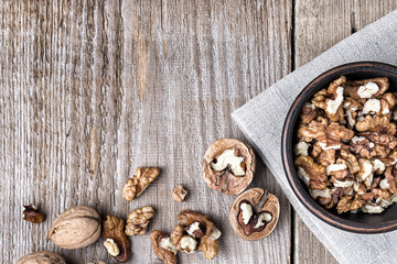 walnuts in a clay plate on a wooden background. top view