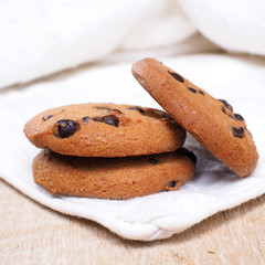 Close up of Chocolate Chip Cookies on white napkin on table.