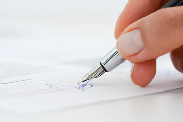Sign a contract or agreement with an ink pen