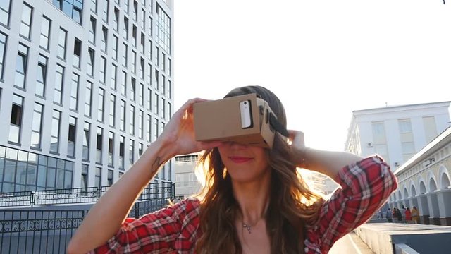 Girl with a device of virtual reality in the city