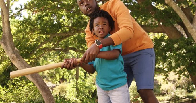 Father is helping his son to play baseball