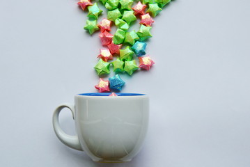 colorful star paper splashing from coffee cup on white background