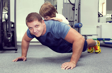 Fototapeta na wymiar father and son do sports in the gym