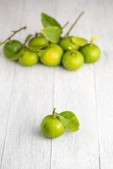green lemon on white wooden