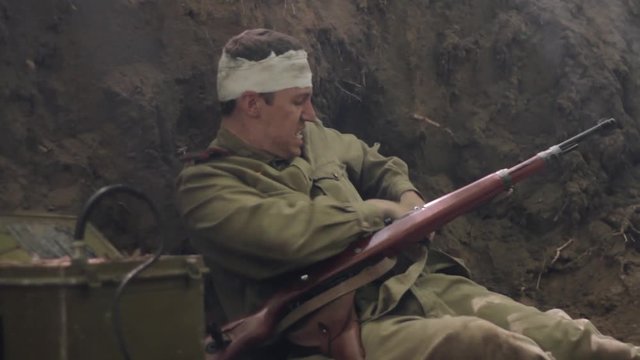 Wounded Soviet soldier during combat runs to portable radio, sits and drinks.